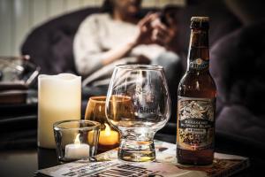 a bottle of beer and a glass on a table at Hôtel Le Refuge in Tignes