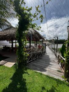 a wooden boardwalk with a restaurant on the water at Cocal Exclusive in Salinópolis +31 photos
