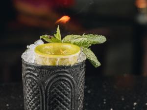 a drink with an orange in a black vase at Boho Club in Marbella