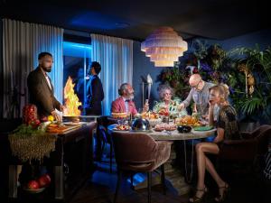a group of people sitting around a table with food at Boho Club in Marbella