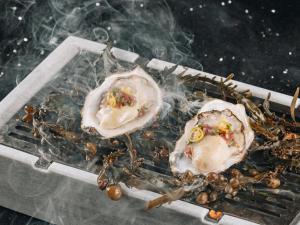 two oysters sitting on top of a grill at Boho Club in Marbella