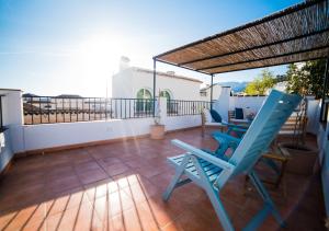 patio z 2 niebieskimi krzesłami na balkonie w obiekcie La Montsiña, acogedora casa de estilo mediterráneo w mieście Cómpeta