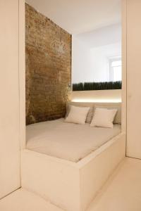 a bed in a room with a brick wall at La Chicca di Sant'Agata in Brescia