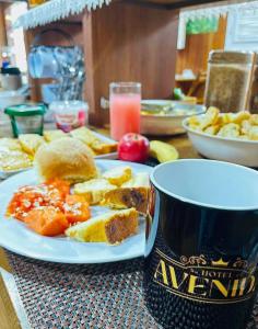 ノバ・フリブルゴにあるHotel Avenidaの食べ物の皿とコーヒーカップが置かれたテーブル