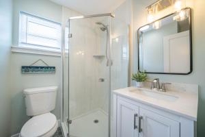 a bathroom with a shower and a toilet and a sink at Surf Shore Properties in North Wildwood +75 photos