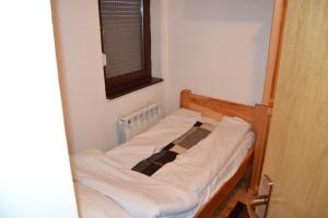 a small bed in a small room with a window at Apartman Kosuta B3 in Jahorina