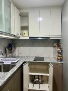 Una cocina con gabinetes blancos y un fregadero. en 1 BR Executive Suite Gentry Manor by JMS, en Manila