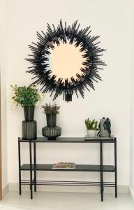 a mirror on the wall above a table with plants at Second Home in Lekki +19 photos