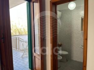 una porta a vetri che conduce a un bagno con servizi igienici di Villa Sarah - Spiaggia a 20m By Cala Salento a Isola della Malva Altre 36 foto