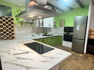 eine Küche mit grünen Schränken und einer Marmoroberfläche in der Unterkunft Refugio entre Montaña y Mar in Perín + 6 Fotos