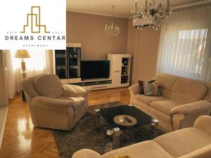 a living room with two chairs and a tv at Apartments Dreams Centar in Živinice