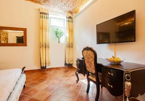 a bedroom with a desk and a television on the wall at Villa Royal B&B in Florence +5 photos