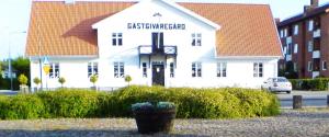 a large white building with a clock on it at Gästis Vandrarhem Örkelljunga in Orkelljunga