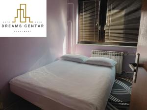 a bed with two pillows on it in a room at Apartments Dreams Centar in Živinice +26 photos