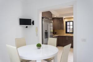 einen weißen Esstisch mit Stühlen und eine Küche in der Unterkunft Exclusive Townhouse in Central Plaza del Duque Close to the Beach in Adeje