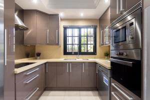 eine Küche mit Geräten aus Edelstahl und einem Fenster in der Unterkunft Exclusive Townhouse in Central Plaza del Duque Close to the Beach in Adeje