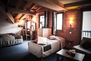 a bedroom with a bed and a couch in a room at Hôtel Le Refuge in Tignes