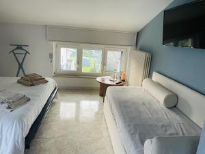 pokój z dwoma łóżkami, stołem i oknem w obiekcie Bed & Breakfast con vista giardino e piscina w mieście Borgofranco dʼIvrea