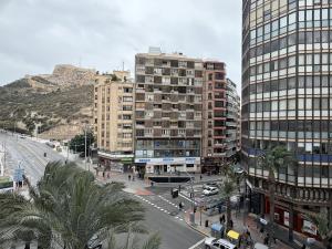a city with tall buildings and a street with palm trees at Lujo alfonso el sabio in Alicante
