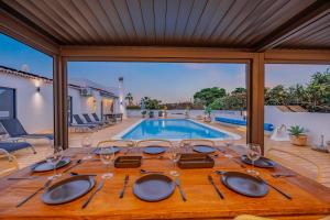 einen Esstisch mit Weingläsern und einen Pool in der Unterkunft Casa Das Flores in Carvoeiro