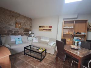 a living room with a couch and a table at Casa das Peleteiro Ribeira Sacra in Ourense +14 photos