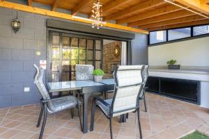 eine Terrasse mit einem Tisch und 2 Stühlen in der Unterkunft Exclusive Townhouse in Central Plaza del Duque Close to the Beach in Adeje
