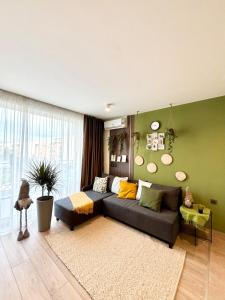 Una sala de estar con un sofá y una pared verde. en Orchid Fort Noks Design, en Sunny Beach