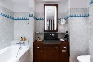 a bathroom with a sink and a tub and a mirror at Grand Hôtel Champs-Elysées in Paris