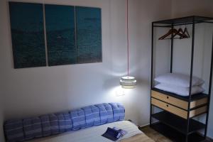 CasaLindos Spitaki في ليندوس: غرفة نوم مع أريكة زرقاء وموقف ليلي