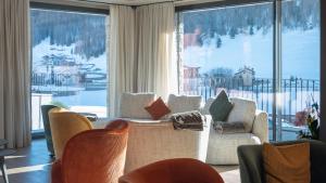 a living room with a couch and chairs and a large window at Paradise Lodge in Livigno