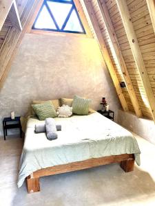 a bedroom with a large bed in a attic at Leisy's Garden Cabins & Dorm in Santa Bárbara de Samaná