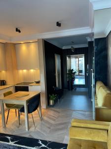 a kitchen and living room with a table and a couch at Golden MOOD City Apartment in Wrocław