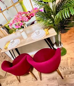 una mesa con 2 sillas rojas y una mesa con flores en 111B Amani Grand Resort Residences Condotel Near Mactan Airport, en Lapu Lapu City
