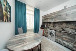 a room with a table and a washing machine at Люкс Крупская 78 in Pavlodar