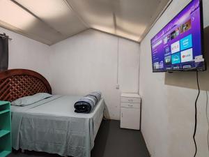 a room with a bed and a tv on the wall at Casa Cálida Relajante y Céntrico con Estacionamiento in San Cristóbal de Las Casas