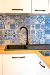 a kitchen with a sink and a blue and white wallpaper at La Baia Blu - Ischia in Ischia
