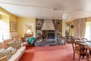 a living room with a fireplace and a stone wall at The Miller's House in Castle Douglas +24 photos
