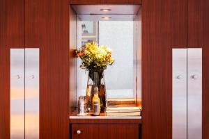 a vase of flowers on a shelf with a mirror at Grand Hôtel Champs-Elysées in Paris
