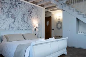 ein Schlafzimmer mit einem weißen Bett und einer Treppe in der Unterkunft Villa Domus Petra in Zagarolo