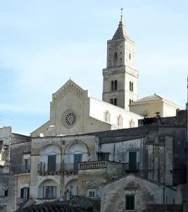 una chiesa con una torre dell'orologio in cima a un edificio di Casa Vacanza "Nel Cuore dei Sassi" a Matera