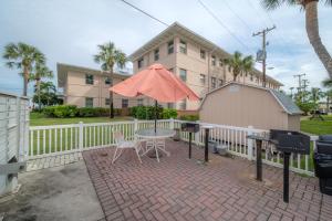 een patio met een tafel en een parasol voor een gebouw bij 6700 Sunset Way Unit 702 in St Pete Beach