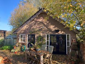 a house with a table and chairs in front of it at Pluk het Geluk in Laag-Soeren