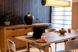 a dining room table with a laptop computer on it at Casa Teva Lisboa Boutique Hotel by chic&basic in Lisbon