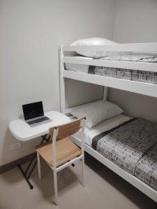 a bedroom with a desk and a laptop on a bed at Charm Residences Building E in Manila +27 photos