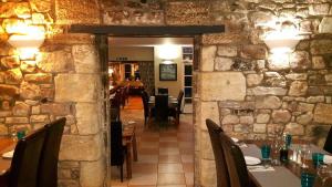 a restaurant with a stone wall and tables and chairs at White Swan Inn in Belford