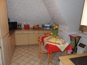 eine Küche mit einem Tisch und einem roten Tischtuch darauf in der Unterkunft Ferienwohnung Karin in Schneverdingen