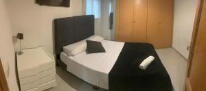 a bedroom with a white bed with a black headboard at Valdavia Habitaciones in Madrid