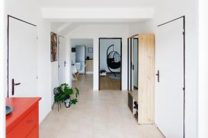 a kitchen with white walls and a red cabinet at Holiday House Rafo in Šamorín