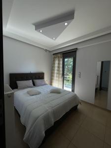 una camera da letto bianca con un letto grande e una finestra di Cactus luxury apartment Oreoi a Oreoi