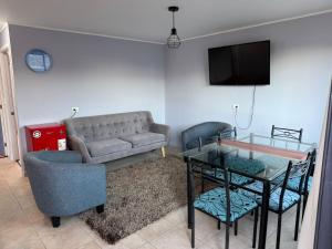 a living room with a couch and a table at Casa independiente muy acogedora in Puerto Varas +4 photos